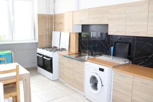 a kitchen with a washing machine and a washer at mHostel24 in Lublin