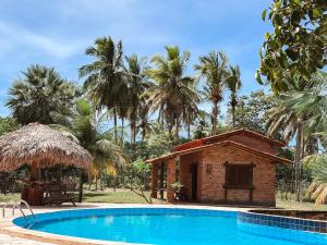 a resort with a swimming pool and a hut at Rancho do Buna in Atins