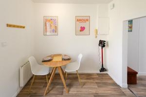 a dining room with a wooden table and white chairs at Studio - Washington 4 in Le Havre