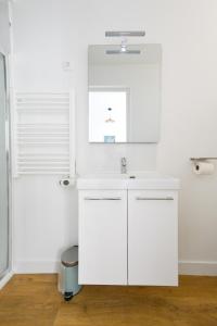 a white bathroom with a sink and a window at Studio - Washington 4 in Le Havre