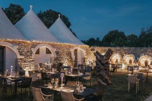 a marquee with tables and chairs in front of a stone building at MASSERIA OSHA ex QUIS UT DEUS 