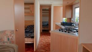 a kitchen with a sink and a stove top oven at Domki Nad Morzem IDPB in Gąski