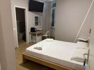 a bedroom with a large white bed and a desk at Le tre Vele in La Spezia