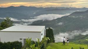 a man and woman standing on top of a hill with mountains at Cheevavavee Doichang Chiangrai in Ban San Pu Loei