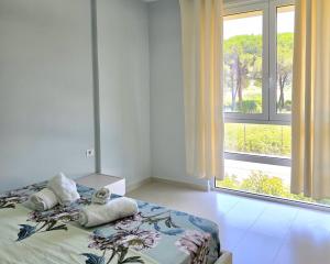 a bedroom with a bed and a large window at San Pietro Happy Stay 280 in Lalzit Bay