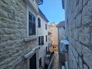 an alley in an old town with buildings at Athos Guesthouse in Kotor +12 photos
