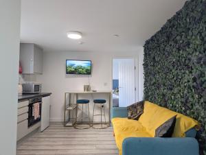 a living room with a couch and a kitchen at Private & Relaxed Apartments 6-10 in Cardiff
