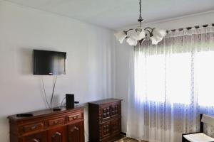 una camera con TV, cassettiera e finestra di Casa do Afonso a Sagres