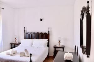 una camera da letto con un grande letto bianco con cuscini bianchi di Casa do Afonso a Sagres