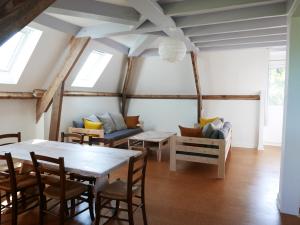 una sala de estar con una mesa y un sofá en Gîte Prétanie, en Piégut-Pluviers 10 fotos más