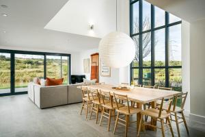 a dining room with a table and chairs and a couch at Everdene OI14 Lakeside Property with Hot Tub at Silverlake Dorset in Warmwell