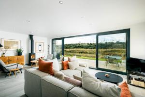 a living room with a couch and a large window at Everdene OI14 Lakeside Property with Hot Tub at Silverlake Dorset in Warmwell