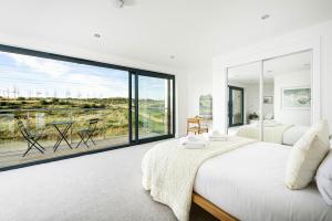 a white bedroom with a large glass window at Everdene OI14 Lakeside Property with Hot Tub at Silverlake Dorset in Warmwell