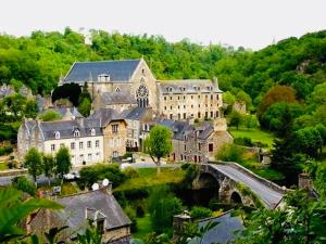 a large building in the middle of a town with a bridge at Magnifique péniche remorqueur à louer in Évran