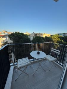 a patio with a table and chairs on a balcony at The Azure Breeze Beachfront Escape in Golem