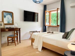 a bedroom with a bed and a desk and a television at Villa Radici in Teramo