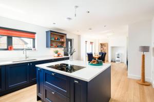 eine Küche mit blauen Schränken und weißen Arbeitsplatten in der Unterkunft Cosy Cottage OI31 Silverlake Dorset in Warmwell