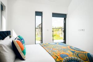 ein Schlafzimmer mit einem Bett und zwei Fenstern in der Unterkunft Cosy Cottage OI31 Silverlake Dorset in Warmwell