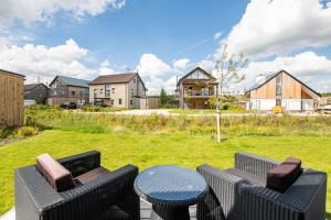 eine Terrasse mit 2 Stühlen und einem Tisch im Hof in der Unterkunft Cosy Cottage OI31 Silverlake Dorset in Warmwell