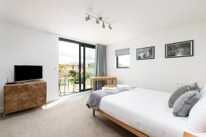 ein Schlafzimmer mit einem Bett und einem Flachbildfernseher in der Unterkunft Songbird SV30 Silverlake Dorset in Warmwell