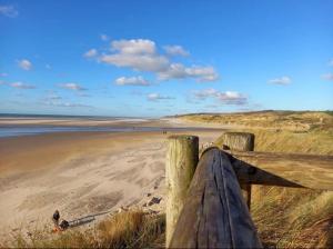 a wooden fence on a beach with the ocean at Chambre vallée de la course in Parenty