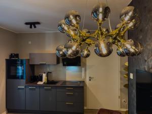 a kitchen with a chandelier in the middle at Golden Suites Weimar in Weimar
