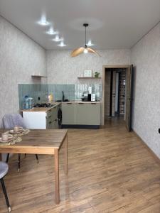 a living room with a table and a kitchen at VIP кв 10 мкр in Oral +3 photos
