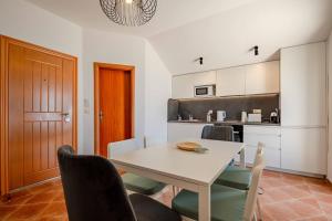 a kitchen with a white table and chairs at Penthouse apartment with panoramic oceanview in Krimovice