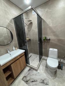 a bathroom with a shower and a toilet and a sink at VIP кв 10 мкр in Oral