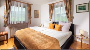 a bedroom with a large bed with orange pillows at Ferienwohnung Kierngaßhäusl in Schönau am Königssee