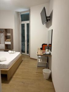 a bedroom with a bed and a desk with a television at Le tre Vele in La Spezia