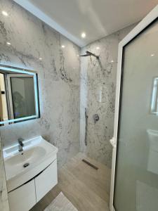 a white bathroom with a sink and a shower at Villa e Diellit in Kaninë +76 photos