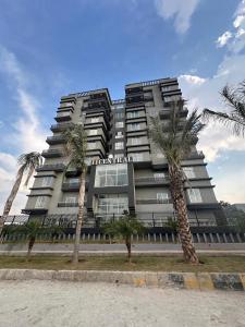Un edificio alto con palmeras delante. en Luxurious 2 bedroom apartment ISB, en Islamabad