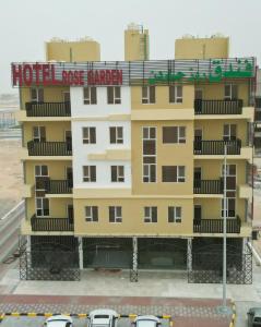 a large yellow building with a sign on it at hotel rose garden فندق روز جاردن in Duqm