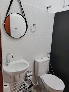Un baño con inodoro, lavabo y espejo. en Suíte Da Rosa, en Cachoeira Paulista 7 fotos más