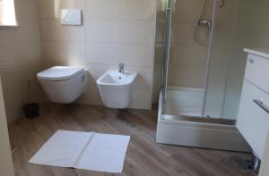 a bathroom with a shower and a toilet and a sink at Apartmani Marin in Vrbnik