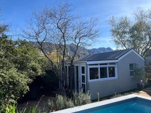 a house with a swimming pool in the yard at Almond Cottage in Riebeek-Kasteel