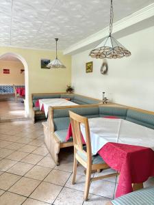 a restaurant with two tables and chairs in a room at Pension Wirt am Bach in Terento