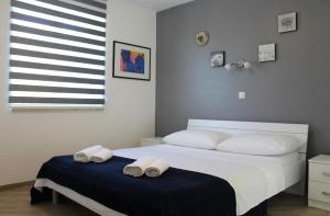 a bedroom with a bed with two towels on it at Apartmani Marin in Vrbnik