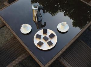 a table with a plate of cake and two cups of coffee at Apartmani Marin in Vrbnik