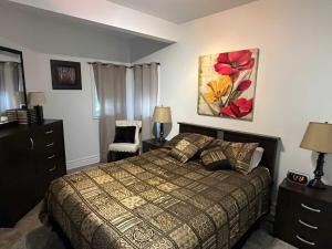 a bedroom with a bed and a painting on the wall at Spa & River - Berges de la Riviere-du-Nord 20 in Prévost +8 photos