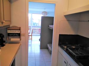 a kitchen with a stove and a view of a balcony at Le Cocon Alpin in Le Dévoluy +3 photos