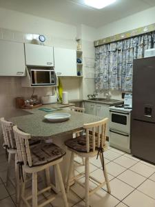 a kitchen with a table and chairs and a refrigerator at South Coast Riviera 203 in Port Shepstone