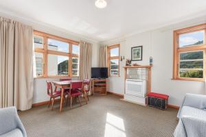 皮克顿The Signal - Stylish Deco Apt with Deck and Marina View的带桌椅和电视的客厅
