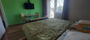 una camera da letto con un letto e una parete verde di ubytovanie michaela a Liptovský Michal