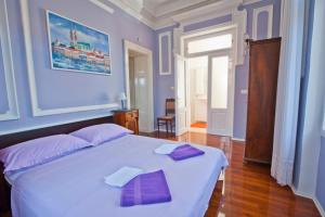 a bedroom with a large white bed with purple pillows at Apartman Isadora in Opatija