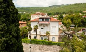 a house on a stone wall in a village at Apartman Isadora in Opatija
