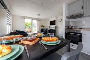 a kitchen with a table with plates of food on it at 32, Woods, Big Garden, Private Parking , AC & Privacy! in Oisterwijk