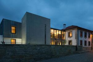 a house with a stone wall next to a building at Casa das Origens in Campia
