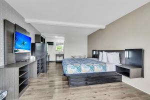 a hotel room with a bed and a flat screen tv at Studio 6 Summerville, SC Charleston in Summerville